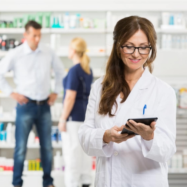 female pharmacist holding digital tablet at pharmacy