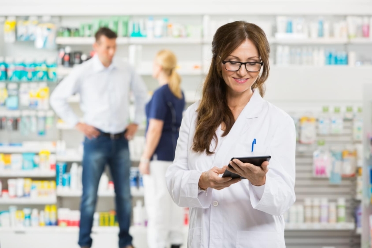 female pharmacist holding digital tablet at pharmacy