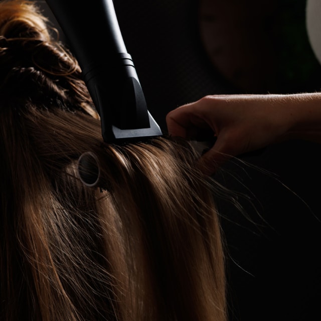 Coiffure avec un sèche-cheveux sur cheveux longs.