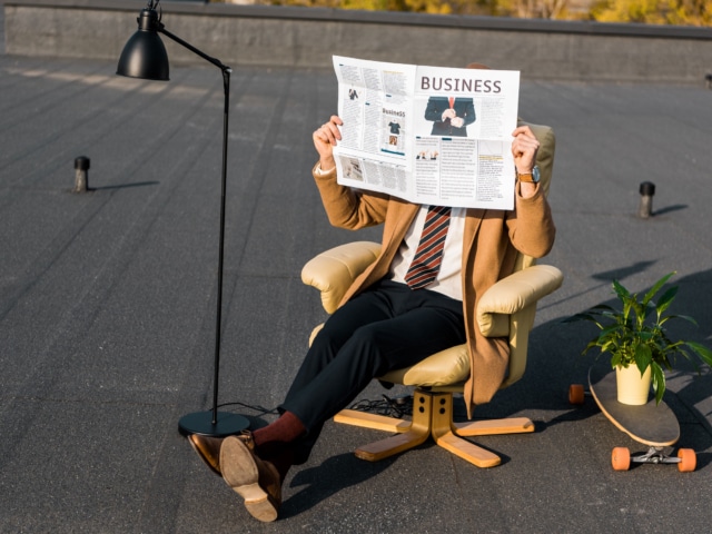 Persone lisant un journal sur un fauteuil afin d'illustrer un service de Rédaction et envoi d'une newsletter d'une agence de communication Landaise