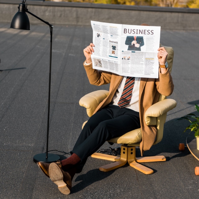 Persone lisant un journal sur un fauteuil afin d'illustrer un service de Rédaction et envoi d'une newsletter d'une agence de communication Landaise